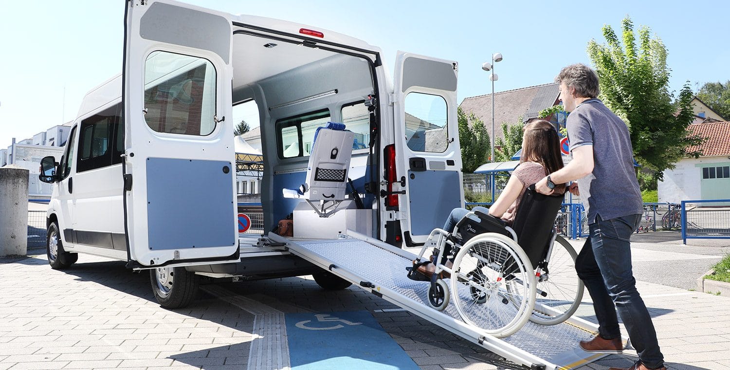 minibus tpmr l3h2 face arrière avec personne en fauteuil roulant sur rampe